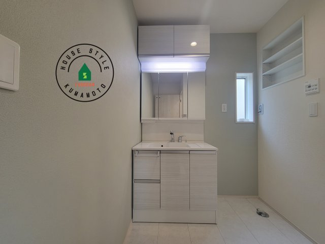 合志市豊岡第4-1棟(1号棟)の内観：施工例|毎日使うものだから清潔な空間を保ちたい水回り。洗面にはそんな願いを解消させてくれる収納アイデアが満載です。三面鏡の裏側にはキャビネットが現れ小物から背の高い物まで収納できます。