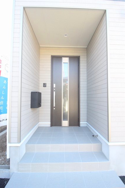 小山市間々田　第11　1号棟の玄関|落ち着いた色合いの玄関ドアが住まいの第一印象を引き締めます。屋根付きで雨の日の出入りも安心です。