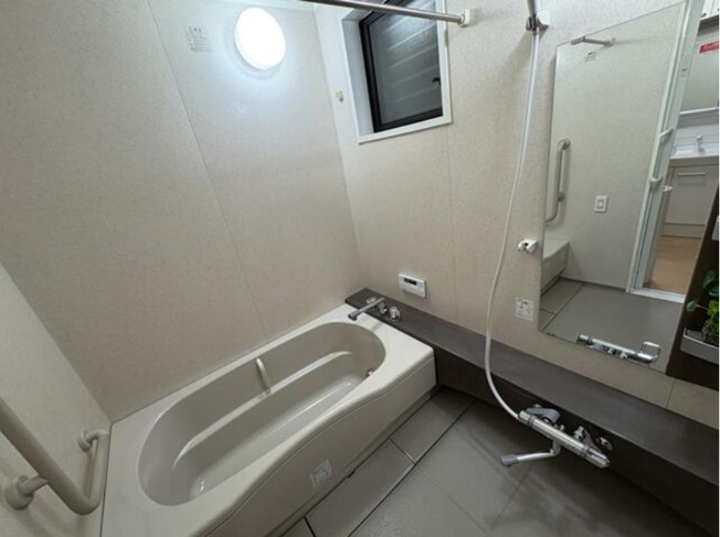 【浴室】 | 大阪市東住吉区東田辺1丁目　中古戸建 | 足を伸ばしてゆったりと湯船に浸かれる広々バスルーム。手すり付きで、立ち座りや移動をサポート！転倒防止にも役立ちます。
