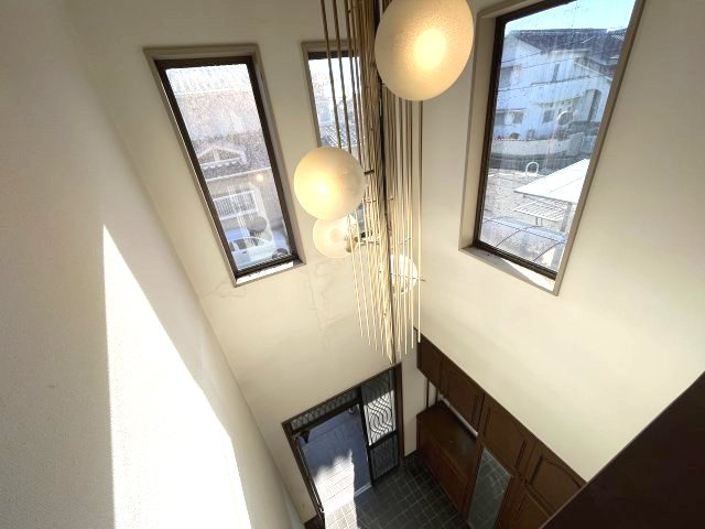 熊取町若葉1丁目　中古戸建の玄関|玄関上部は大きな吹き抜けがあり日中明るい空間です。
電球は電動で上げ下げ可能です。