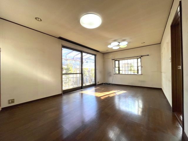 熊取町若葉1丁目　中古戸建の居間・リビング|木目調のフローリングで開放感のあるリビング。大きな窓で採光良好。
和室は間仕切りで仕切れます。