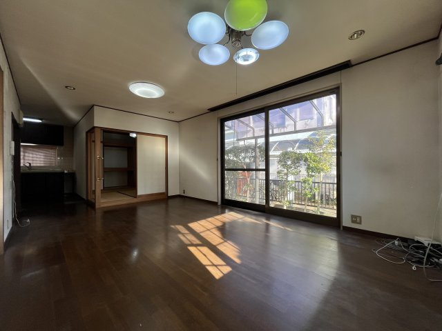熊取町若葉1丁目　中古戸建の居間・リビング|木目調のフローリングで開放感のあるリビング。大きな窓で採光良好。
和室は間仕切りで仕切れます。