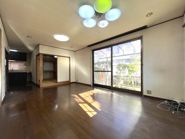 熊取町若葉1丁目　中古戸建の居間・リビング|木目調のフローリングで開放感のあるリビング。大きな窓で採光良好。
和室は間仕切りで仕切れます。