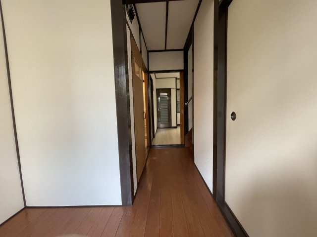 垂水区五色山2丁目の内装|【1階廊下】ダイニングキッチンへとつながる廊下。ダークブラウン×ホワイトの内装が温もりと落ち着きを感じさせてくれます。