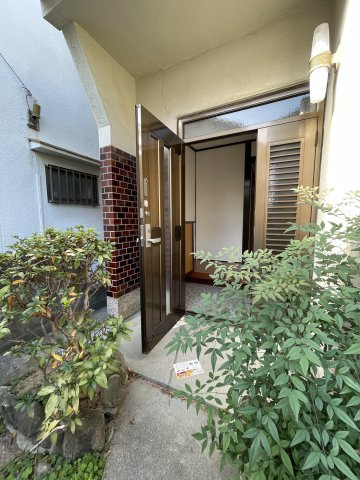 垂水区五色山2丁目の玄関|【玄関】玄関アプローチには植栽が植えられ、プライバシー性が高められています。モニター付きインターホンが設置され、防犯面にも配慮されています。