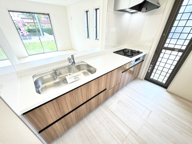 リーブルガーデンS  高崎箕郷町生原第7　2号棟のキッチン|人気のカウンターキッチン採用です☆ゴミ出しに便利な勝手口付き！
コンロも３口ご用意しています！調理スペースも広くストレスなくお料理できます。
浄水器つきなので美味しいお水も飲めますよ♪