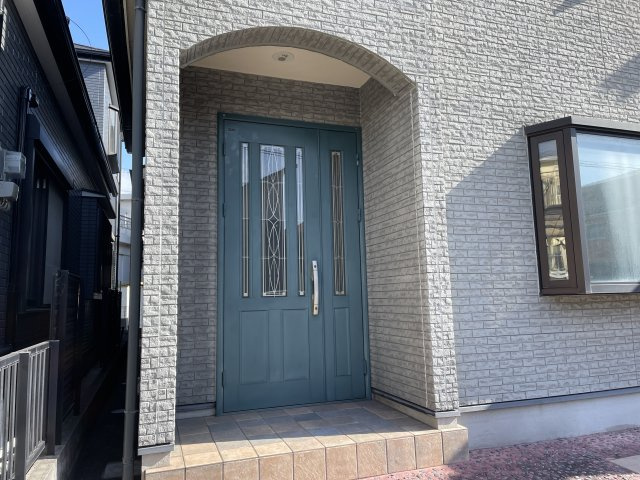 明石市大久保町大窪 戸建の玄関|【玄関ポーチ】アーチ型のポーチ×爽やかな色合いの玄関ドアが採用された、デザイン性の高い玄関スペース。ダウンライトが備わり、遅い帰宅時でもご家族を明るく迎えてくれます。