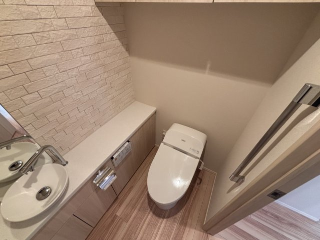 トイレ、手洗い場付き、ウォシュレット付き、壁面はエコカラット仕様です。