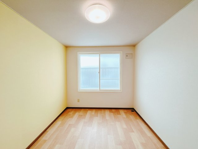 【洋室】 | 北見市中ノ島町３丁目１３番７号　中古売家 | 【リフォーム後】2階南東側の洋室写真です。こちらは壁、天井のクロス貼替を行い床はクッションフロアを上張りして仕上げました。照明器具も交換致しました。
