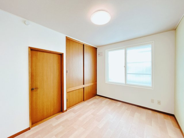 【洋室】 | 北見市中ノ島町３丁目１３番７号　中古売家 | 【リフォーム後】2階南西側の洋室写真です。こちらは壁、天井のクロス貼替を行い床はクッションフロアを上張りして仕上げました。照明器具も交換致しました。