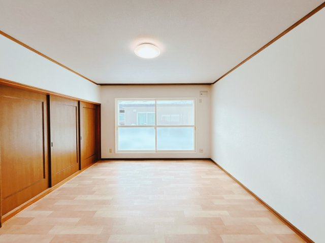 北見市中ノ島町３丁目１３番７号　中古売家の洋室|【リフォーム後】和室側から見た別アングルのリビング写真です。南側に大きな窓があり明るいリビングです。壁、天井クロスの貼替、床はクッションフロア上張りを行いました。照明器具も交換致しました。