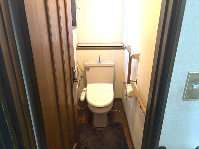 売中古戸建　沼津市東椎路のトイレ|コンパクト設計のロータンクトイレで、手すりも備わった安心の仕様です。