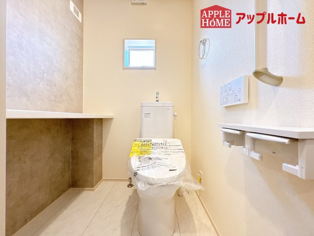 [新築住宅] 鶴ヶ島市羽折町 全4棟のトイレ|白を基調とした清潔感のある明るい空間。温水洗浄便座付きで、毎日快適・清潔に使用できます。操作しやすい壁面リモコンを採用しています。