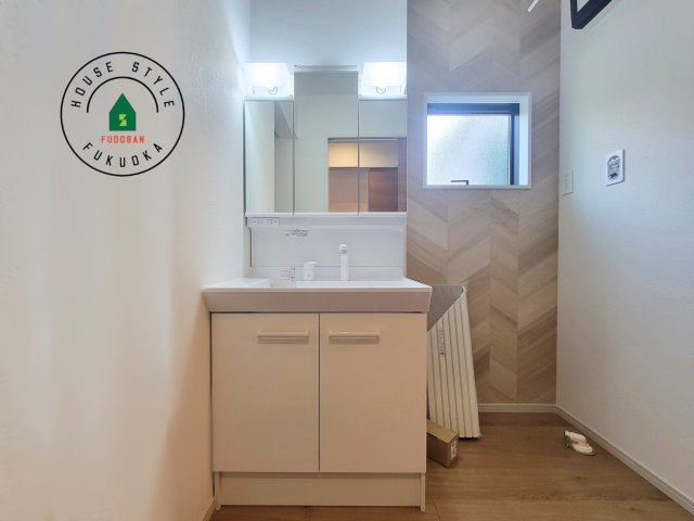 福岡市早良区内野５丁目第1-3棟（3号棟）の内観：施工例|毎日使うものだから清潔な空間を保ちたい水回り。洗面にはそんな願いを解消させてくれる収納アイデアが満載です。三面鏡の裏側にはキャビネットが現れ小物から背の高い物まで収納できます。