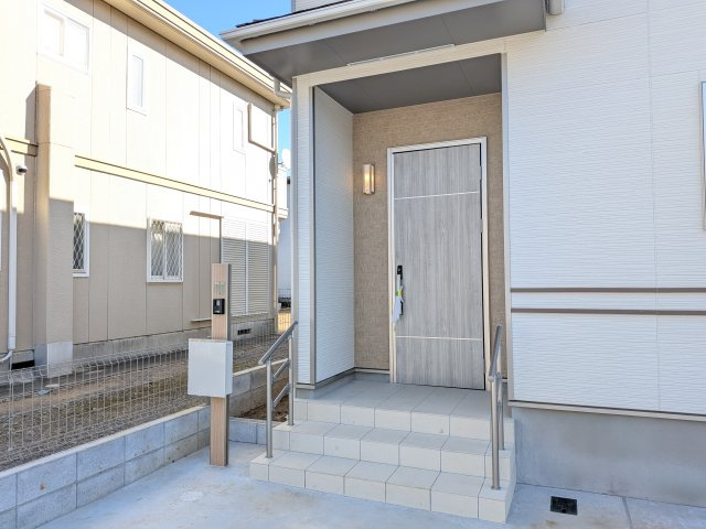 守谷市薬師台7丁目16番　新築戸建　C号棟の玄関|お洒落な玄関ドアと洗練された外壁デザイン。家の顔にふさわしい上質な佇まいで、ご家族やお客様を迎えます。