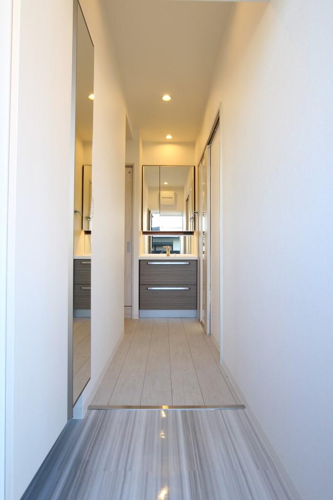 フクダ不動産八木駅前マンションの居間・リビング|等身大鏡シューズボックス付き玄関