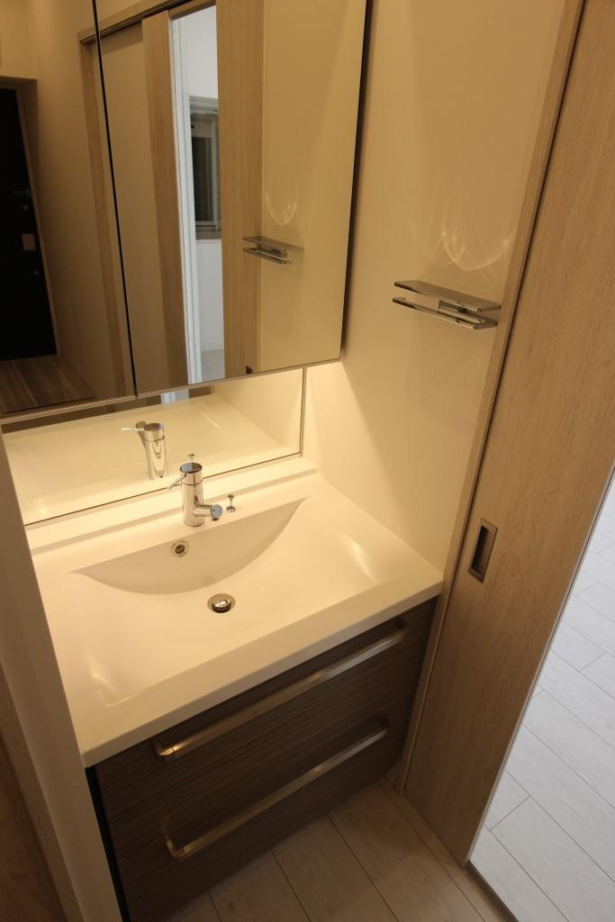 フクダ不動産八木駅前マンションの洗面所|大きな二面鏡付き化粧洗面台　鏡の裏に収納スペースあり