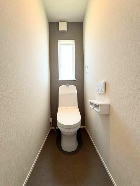 須賀一丁目　新築のトイレ|明るい光が差し込む窓付きのトイレです。シンプルな内装で清潔感があります。使いやすい配置で落ち着いた雰囲気が演出されています。床材はお手入れもしやすく衛生的です。