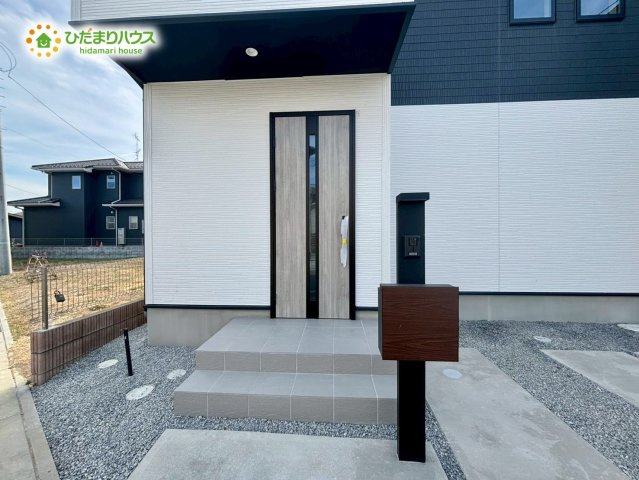 熊谷市上之　3期　新築一戸建て　グラファーレ　02の玄関|屋根のあるアプローチ部分は、雨の日のベビーカーの乗せ降ろしや傘の開閉も濡れずに行えて非常に便利です！
玄関まわりはスッキリとした印象で、季節のプランターを置いて彩りを添えるのも楽しみになります♪