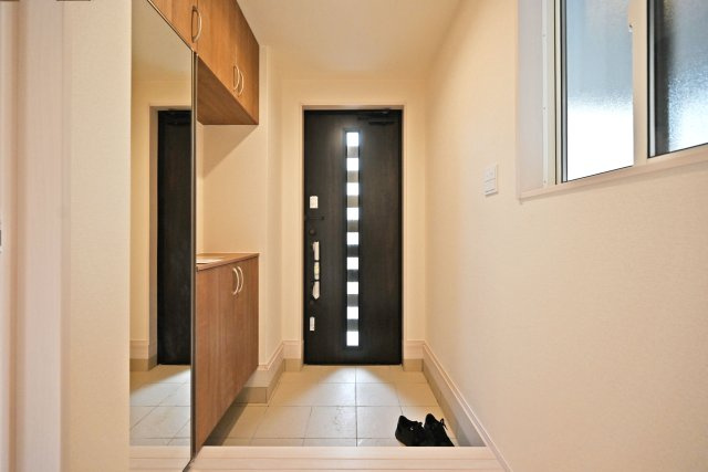ブルーミングガーデン浜甲子園1丁目新築一戸建て│3LDK+駐車1台可の玄関|1階玄関をホール側から撮影した内観写真です。 シンプルな玄関扉にシューズボックス、小窓を配置したオーソドックスな玄関です。
