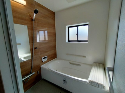 【浴室】 | 鶴見区諸口１丁目中古戸建 | 木目調のアクセントパネルで、お部屋のようなリラックス空間を演出するバスルーム。