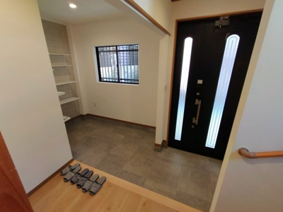 【玄関】 | 鶴見区諸口１丁目中古戸建 | 広々シューズクロークつきの玄関は、ベビーカーや大きな荷物の一時置きにも活躍。玄関ドアや窓から光を取り込む明るい空間です。