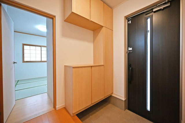 尼崎市大島1丁目中古戸建｜4LDK+駐車1台可の玄関|1階玄関をホール側から撮影した内観写真です。 シンプルな玄関扉にシューズボックスを配置したオーソドックスな玄関です。