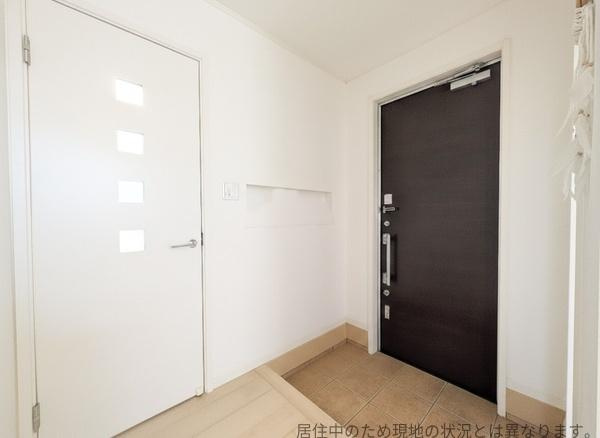 南新町（角子原）中古の玄関|玄関は白とダークブラウンのコントラストが特徴的です。すっきりとしたデザインでスペースも確保されています。