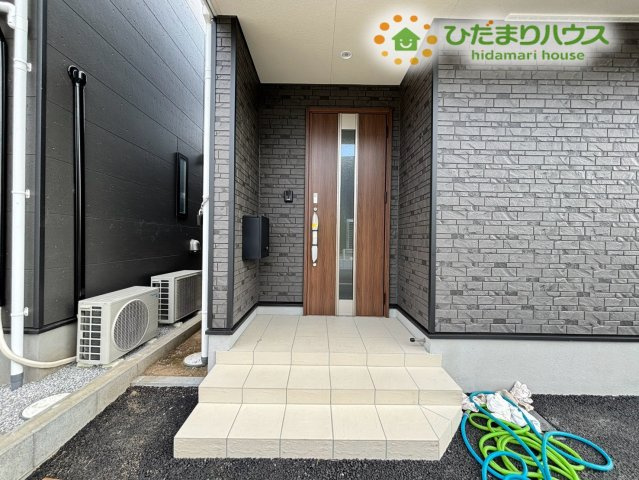 鴻巣市鴻巣　第1　新築一戸建て　クレイドルガーデン　02の玄関|屋根付きのアプローチが嬉しい玄関エリアです！雨の日でも濡れずに落ち着いて鍵の開け閉めができますよ。木目調のおしゃれな扉が印象的で、毎日のお出かけやご帰宅を暖かく迎えてくれる玄関周りです♪