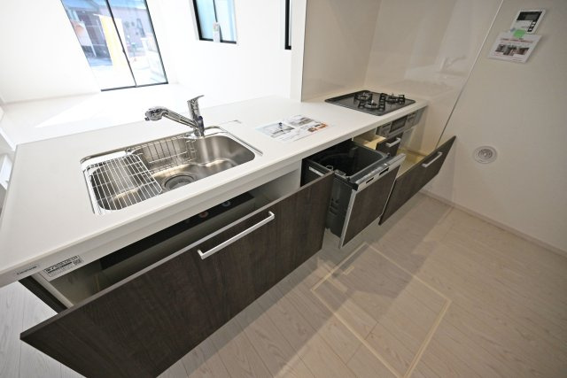 テラシエ寺本3丁目新築一戸建て│4LDK+駐車並列2台可(車種制限有)のキッチン|キッチン天板下いっぱいに収納庫を設けてあります。シンクした収納庫にはナイフホルダーも標準搭載。食器洗い乾燥機や浄水器一体型水栓も標準仕様のユニットが導入されています。