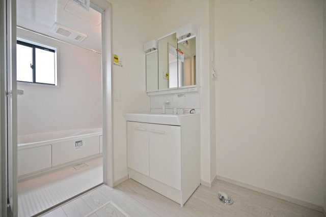 テラシエ寺本3丁目新築一戸建て│4LDK+駐車並列2台可(車種制限有)の独立洗面台|洗面室に入ってすぐの内観写真です。900mm幅のシャンプードレッサーを導入しており、広々と使用できます。十分な明るさのある2照明を採用し、朝支度もスムーズに進みます。