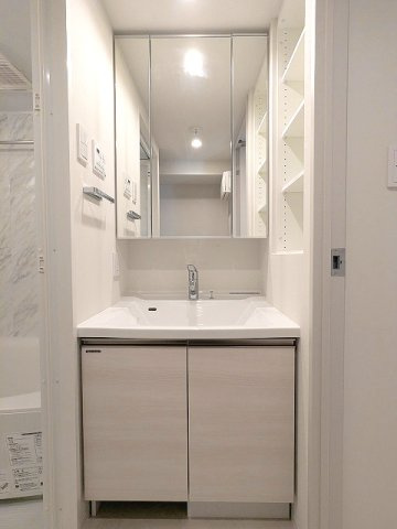 CLARITIA文京湯島の洗面所|トイレと独立した洗面脱衣室、三面鏡付ハンドシャワー付洗面台、洗面台下にヘルスメーターストックあります、洗面室に洗濯機置場あります