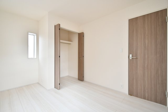 白岡市小久喜4期の洋室|洋室②：勾配天井を採用し、実際の面積以上の開放感を創出しました。木の温もりを感じる建具と白い壁のコントラストが清潔感を演出し、どんなインテリアも映える空間です。