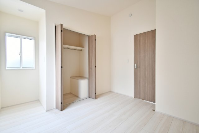 白岡市小久喜4期の洋室|洋室③：白を基調とした内装に、ナチュラルな木目調の建具が映える清潔感のある空間。勾配天井による縦の広がりは、お子様部屋やテレワークスペースにもおすすめ。