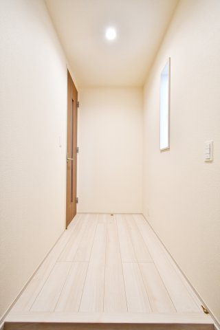 白岡市小久喜4期の玄関|木の温もりを感じる明るいホール。採光窓からの柔らかな光が開放感のある住空間を演出します。無駄のない動線設計で、リビングへと優しく導くデザイン。清潔感あふれる白を基調とした内装が心地よい毎日を叶えます。