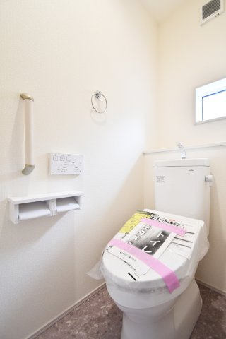 白岡市小久喜4期のトイレ|清潔感あふれる白で統一された空間。窓からの自然光が明るく、換気もしやすい快適設計です。温水洗浄便座や手すりを標準装備し、幅広い世代に配慮しました。お掃除のしやすさも魅力の、毎日使う大切な場所です。