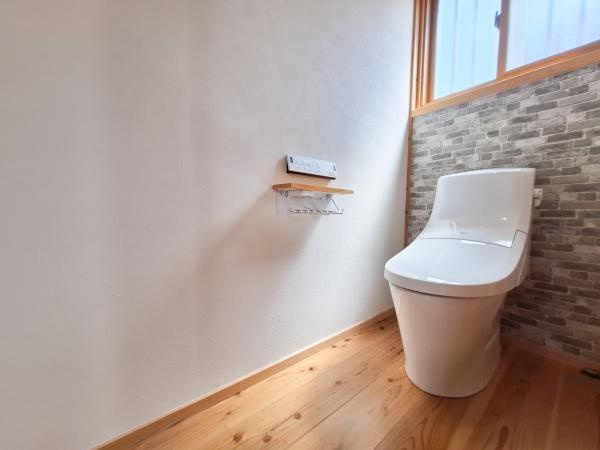 角子原二丁目　戸建てのトイレ|清潔感のあるトイレ空間です。木目調の床が温かみを演出しています。窓があり自然光が差し込む明るい印象です。収納や小物置きにも配慮された設計です。