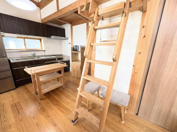 角子原二丁目　戸建ての内装|ナチュラルな木目が際立つ室内です。コンパクトながらも使いやすいキッチンを備えています。ロフトに上がる梯子が設置されており空間を有効に活用できます。