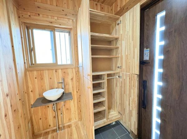 角子原二丁目　戸建ての玄関|木の温もりが感じられる玄関スペースです。収納棚が充実しており整理整頓に便利です。窓から自然光が入り明るい空間となっています。シンプルな洗面台も設置されていて使い勝手が良い印象です。