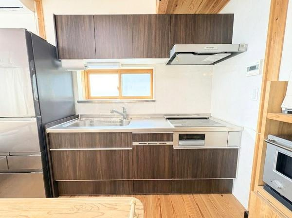 角子原二丁目　戸建てのキッチン|シンプルなデザインのキッチンが印象的です。窓からの光が明るさをもたらします。収納スペースが多く家事がしやすい環境です。木目調の扉が空間に落ち着きを与えています。