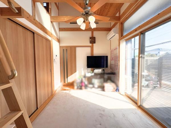 角子原二丁目　戸建ての居間・リビング|天井が高く開放感のあるリビングです。大きな窓から光がたっぷり差し込み室内が明るい印象です。木目調のデザインが温かみを感じさせます。天井ファンや収納スペースもあり機能性にも配慮されています。