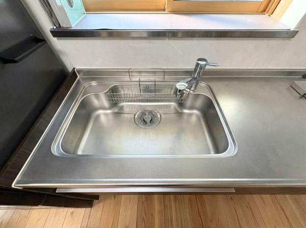 角子原二丁目　戸建てのキッチン|ステンレス素材のシンクはお手入れがしやすく清潔感があります。シンプルなデザインで使い勝手に配慮されています。窓が近く明るい光が差し込むキッチンスペースです。日常の作業にも便利な配置となっています。
