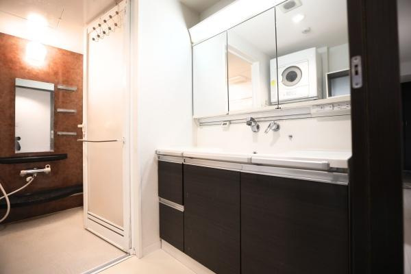 ラグジン高松西の独立洗面台|広々とした洗面所は収納スペースが豊富で日用品もすっきり収まります。大きなミラーが設置され明るく清潔感のある雰囲気です。