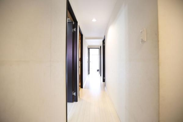 ラグジン高松西の内装|白を基調とした廊下は室内に明るさをもたらします。シンプルなデザインが特徴です。直線的なラインがすっきりとした印象を演出します。天井照明も効果的に配置されています。