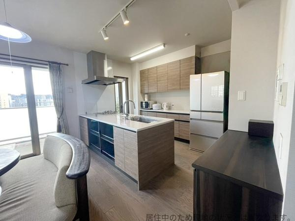 グリーンヒル大分駅前レジデンスの居間・リビング|明るい光が差し込むリビングが魅力です。キッチンとダイニングの動線がスムーズで快適に過ごせます。収納スペースも豊富に備えられています。落ち着いた色合いです。