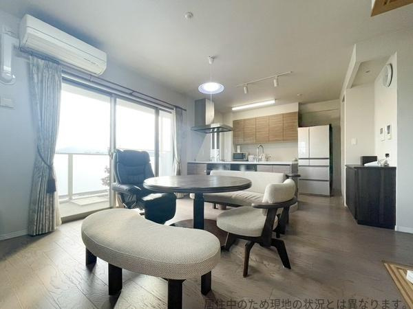 グリーンヒル大分駅前レジデンスの居間・リビング|広々としたリビングが印象的です。大きな窓から明るい光が差し込み開放感があります。ダイニングとリビングが一体となっており使い勝手も良さそうです。落ち着いた色合いの床で家具のレイアウトも楽しめます。