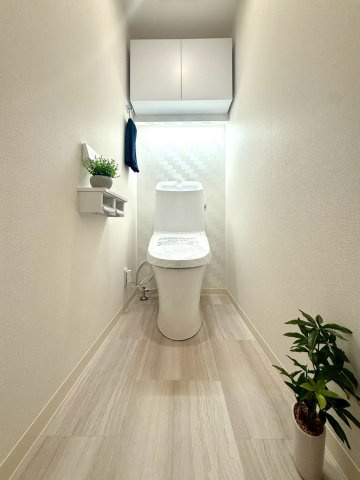 ライオンズマンション根岸第5のトイレ|清潔感あふれるトイレ空間。シンプルで上品な内装と収納付き設計により、すっきりとした印象と快適さを両立しています。