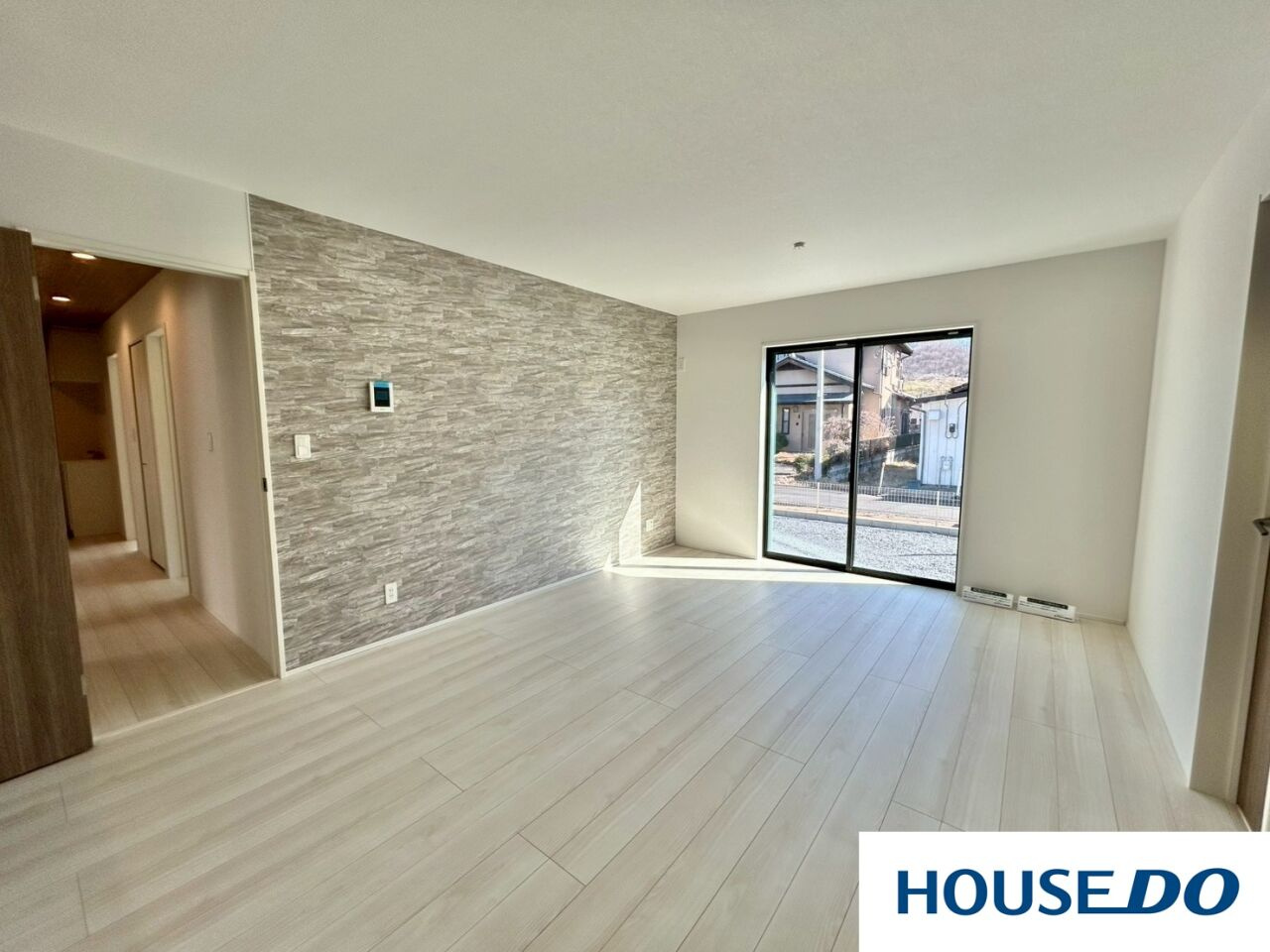 新築戸建　桐生市東5丁目の居間・リビング|石目調アクセントが映える、20帖超の広々LDK！ 大きな掃き出し窓から自然光がたっぷりと注ぐ、明るく開放的なリビングダイニングです！