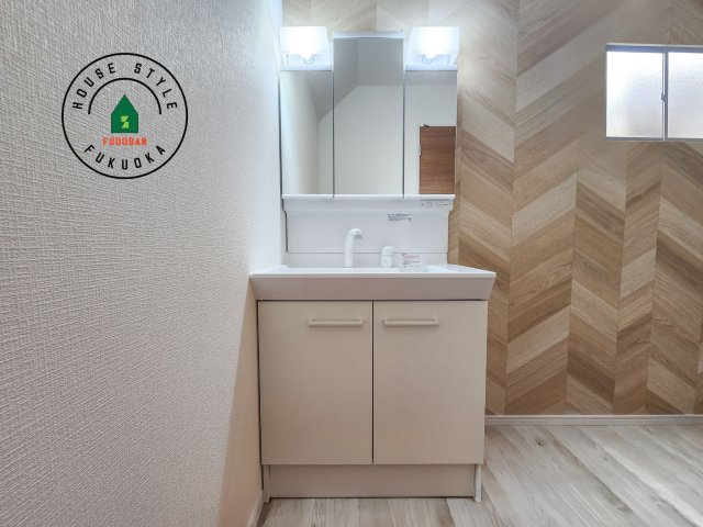 太宰府市五条6丁目第3-2棟（2号棟）の内観：施工例|毎日使うものだから清潔な空間を保ちたい水回り。洗面にはそんな願いを解消させてくれる収納アイデアが満載です。三面鏡の裏側にはキャビネットが現れ小物から背の高い物まで収納できます。