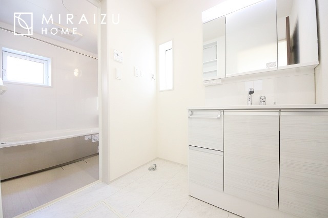 【洗面所】 | 洗濯機置き場と脱衣スペースもしっかりと確保されている洗面室、洗面コーナーは、窓から陽も差し明るく開放的な造りです。家事導線も良いので洗濯物やお湯はりもストレスフリーに毎日家事を楽しめそうです。
